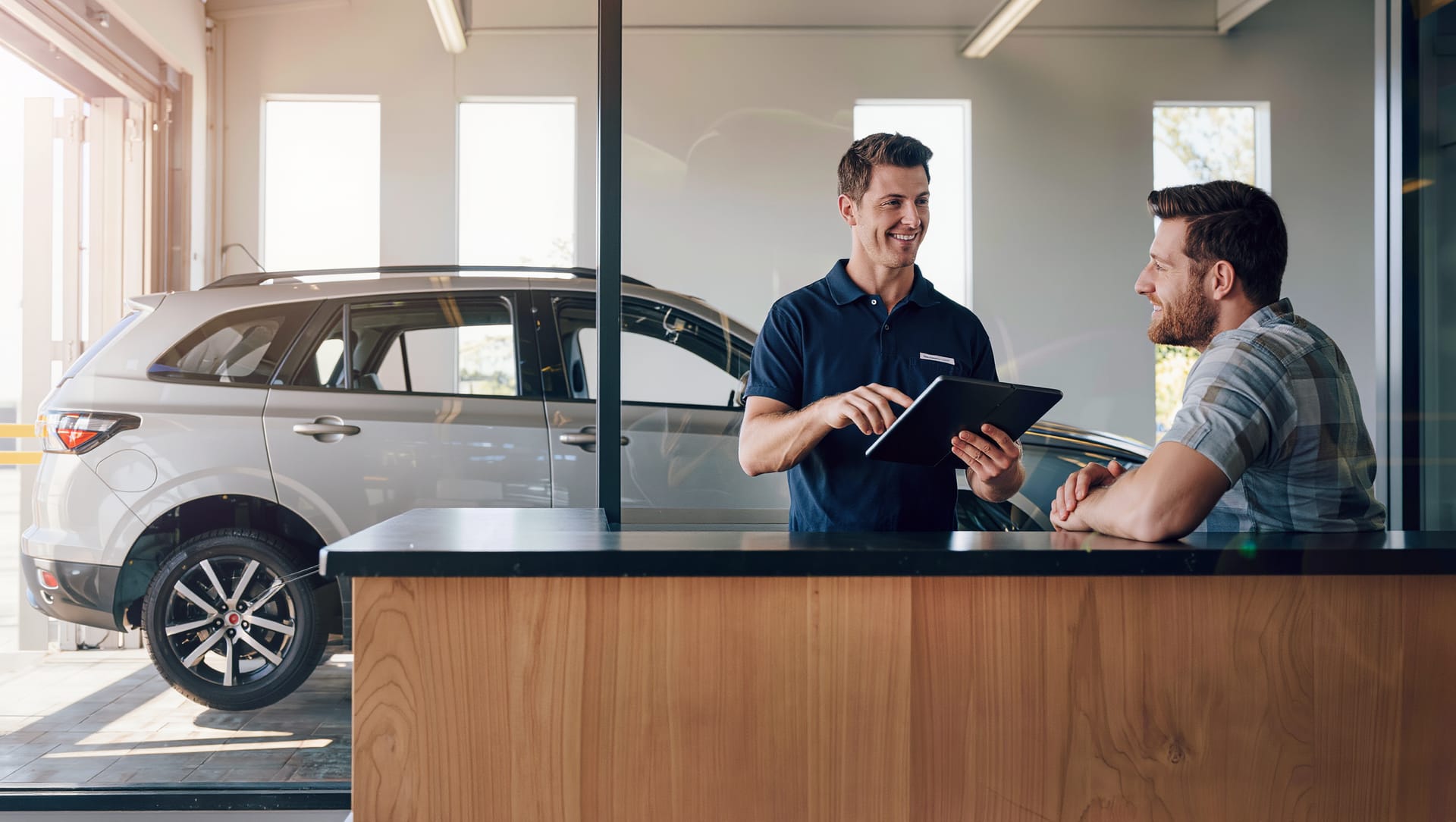 Staff member going through an insurance claim with a customer at the front counter