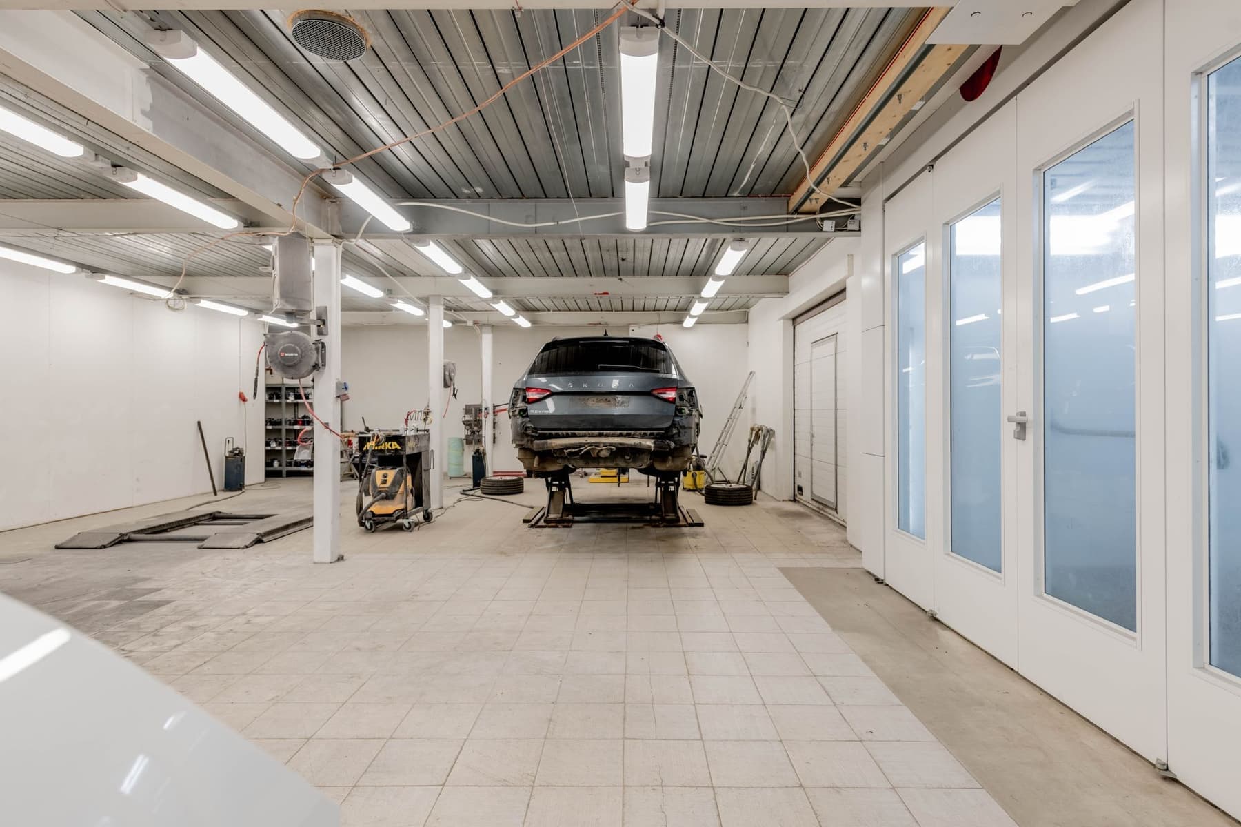 Vehicle elevated on a hydraulic lift for a full body-repair assessment