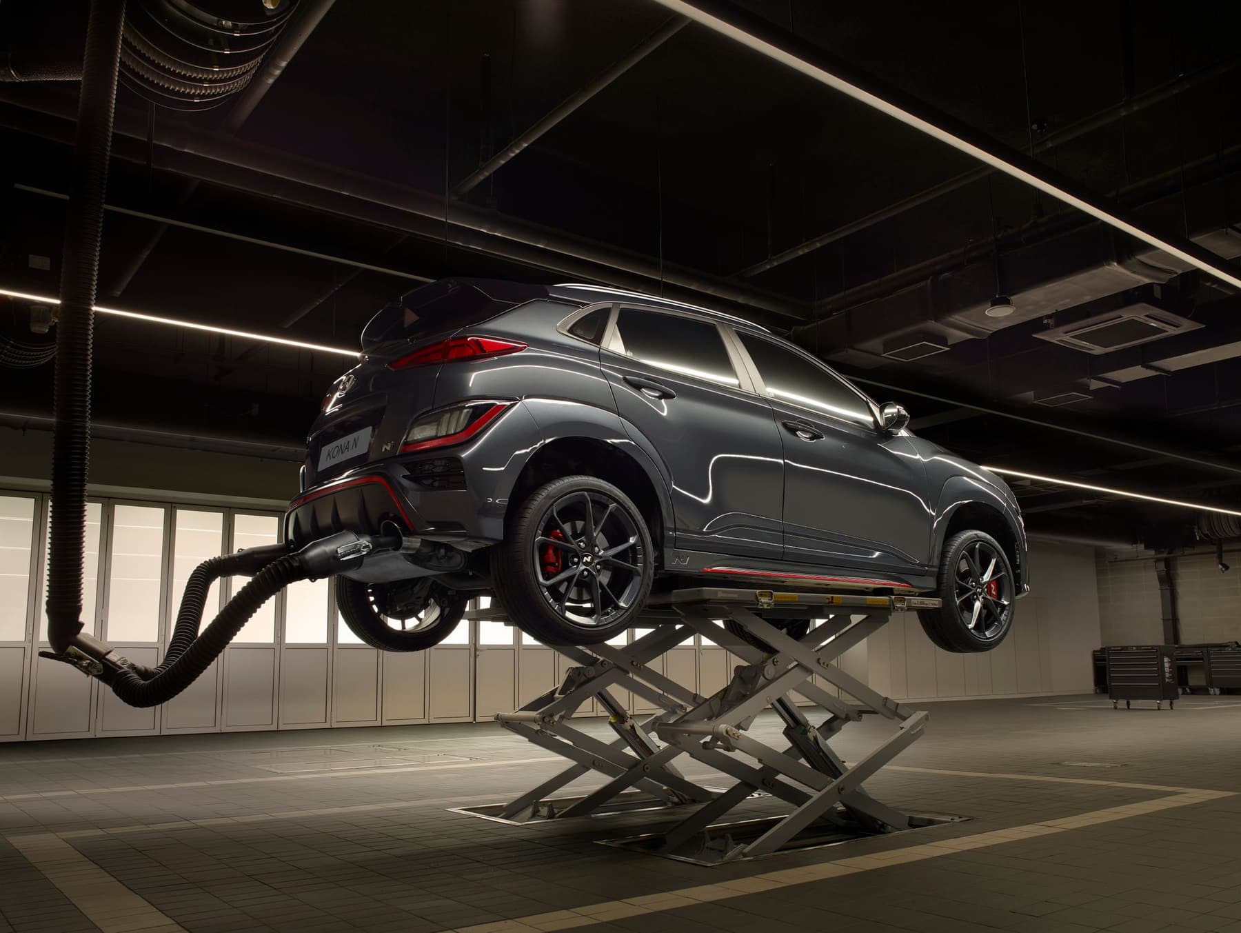 Vehicle elevated on a scissor lift in a high-tech workshop bay
